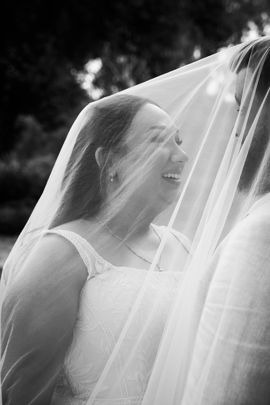 Black and white photo of Karina smiling beneath her veil